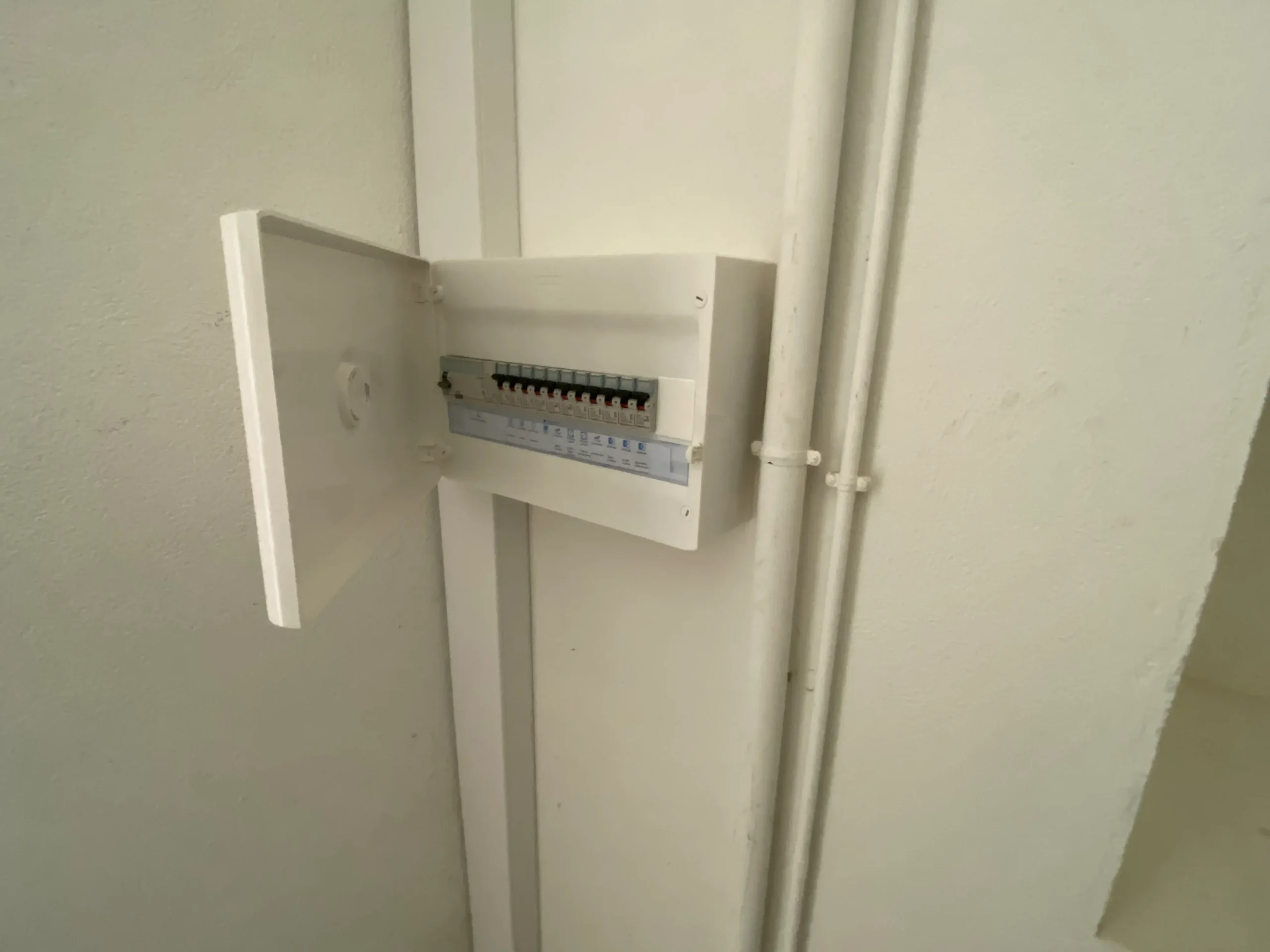 Électricien installant une borne pour véhicule hybride rechargeable